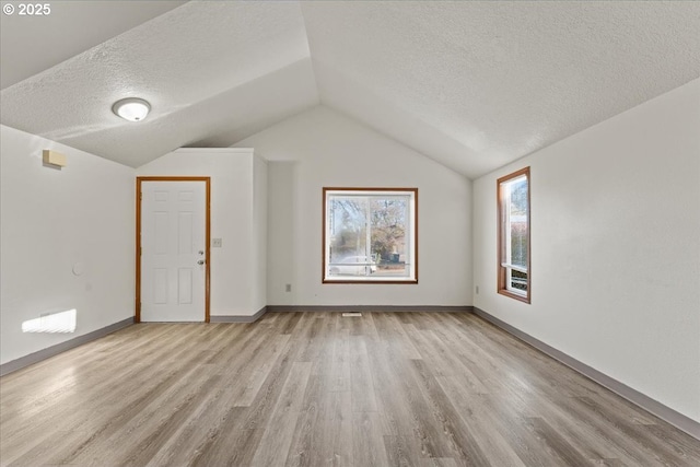 2427 SW 218th Dr, Beaverton, OR 97003 - bonus room featuring a textured ceiling, light wood finished floors, vaulted ceiling, and baseboards