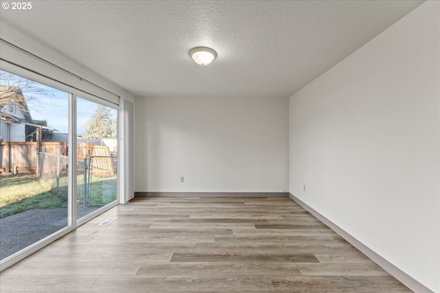 2427 SW 218th Dr, Beaverton, OR 97003 - unfurnished room with wood finished floors, a textured ceiling, and baseboards