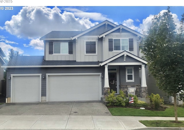 craftsman inspired home featuring board and batten siding, stone siding, driveway, and an attached garage