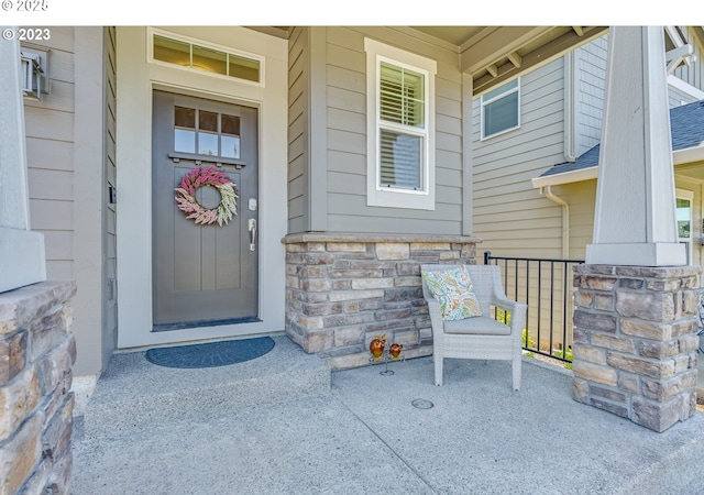 entrance to property featuring stone siding and a porch