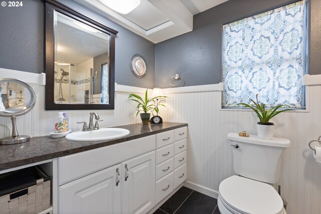 bathroom featuring tile patterned flooring, vanity, an enclosed shower, and toilet