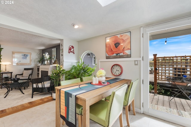 dining space featuring light tile patterned floors and a textured ceiling