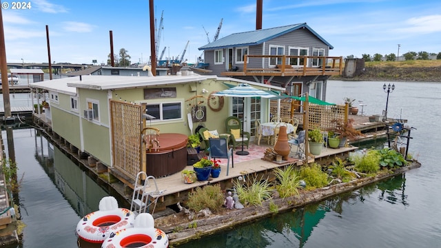 view of dock featuring a hot tub and a water view