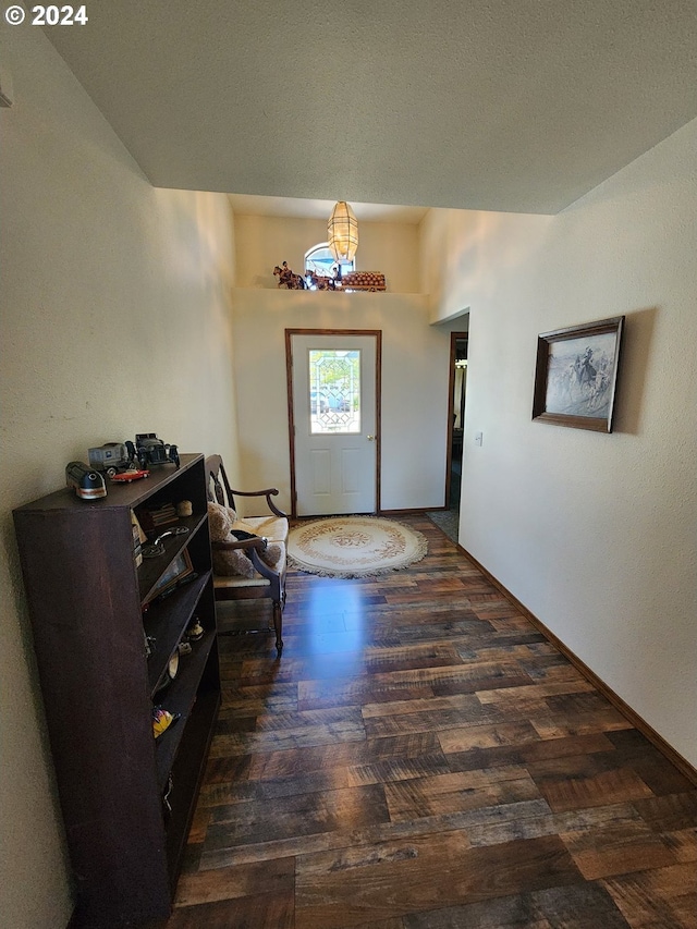 hall featuring dark wood-type flooring and vaulted ceiling