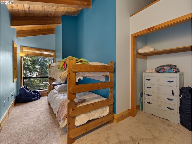 carpeted bedroom with lofted ceiling with beams and wooden ceiling