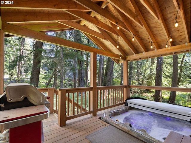 unfurnished sunroom with wood ceiling, a hot tub, a wealth of natural light, and vaulted ceiling with beams