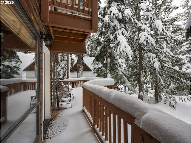 view of snow covered back of property