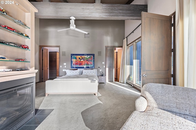 bedroom featuring dark colored carpet, a high ceiling, and ceiling fan