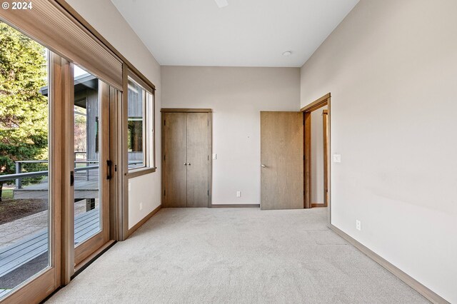 45650/45646 Mckenzie Hwy, Vida, OR 97488 - unfurnished bedroom featuring multiple windows, carpet, and access to exterior