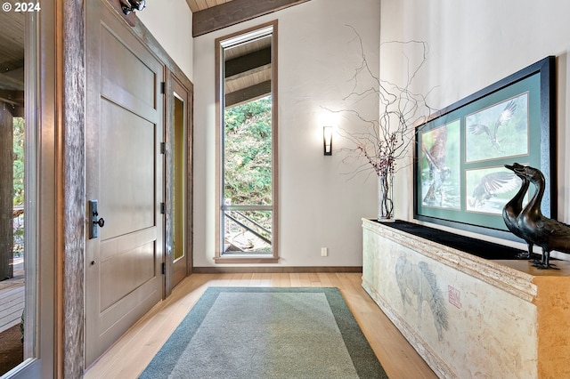 entrance foyer featuring beam ceiling and light wood-type flooring