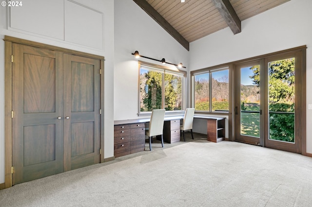 unfurnished office featuring a barn door, wooden ceiling, light carpet, and high vaulted ceiling