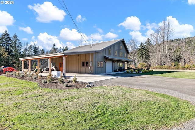 view of side of property with a carport and a lawn