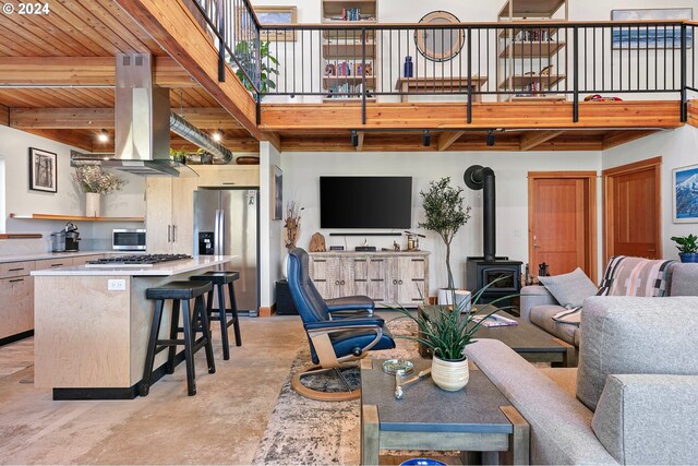 45650/45646 Mckenzie Hwy, Vida, OR 97488 - living area featuring a wood stove, concrete flooring, and wooden ceiling with exposed beams