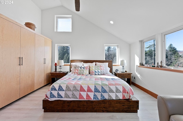 bedroom featuring light hardwood / wood-style floors, high vaulted ceiling, multiple windows, and ceiling fan