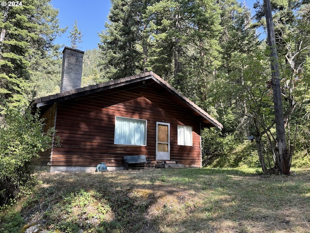 view of side of property with entry steps and a chimney