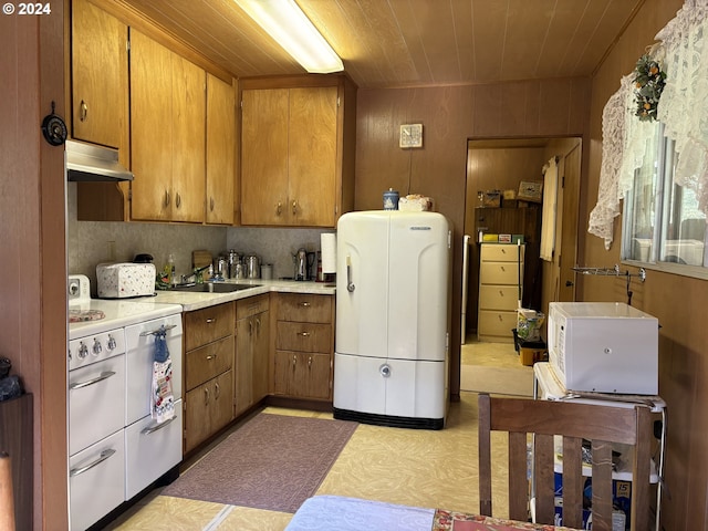 kitchen featuring brown cabinets, light countertops, a sink, double oven range, and under cabinet range hood