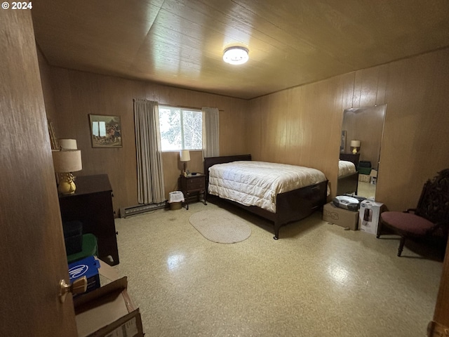 bedroom with wood walls and a baseboard heating unit