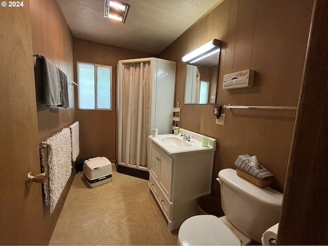 bathroom with toilet, wooden walls, vaulted ceiling, and vanity