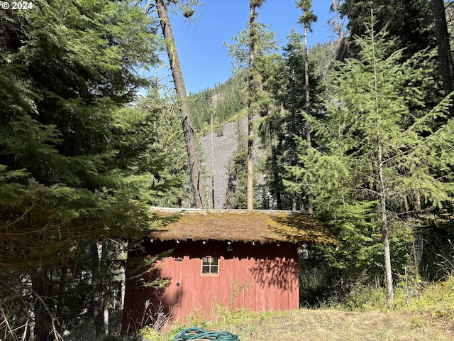 view of property exterior with a view of trees