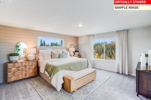 bedroom with carpet flooring, wooden walls, and baseboards