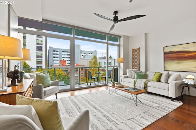 living room featuring ceiling fan, expansive windows, a healthy amount of sunlight, and hardwood / wood-style flooring