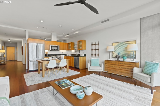 living room with ceiling fan and dark wood-type flooring