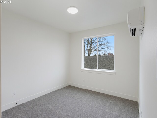 carpeted spare room with a wall mounted air conditioner