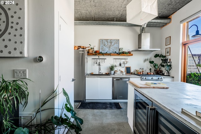 411 NW Flanders St Unit 805, Portland, OR 97209 - kitchen with open shelves, concrete floors, wine cooler, stainless steel appliances, and wall chimney exhaust hood