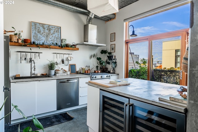 bar featuring wine cooler, exhaust hood, appliances with stainless steel finishes, white cabinetry, and sink