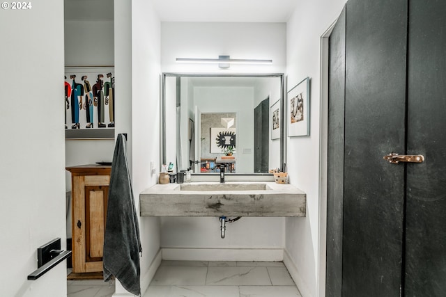 411 NW Flanders St Unit 805, Portland, OR 97209 - bathroom with baseboards, a sink, and marble finish floor