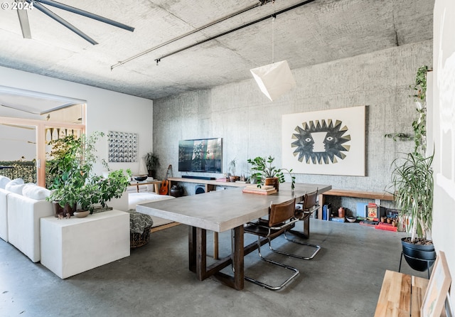 dining space with concrete floors and ceiling fan