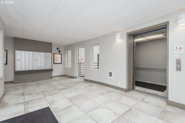 unfurnished room with mail boxes and light tile patterned floors