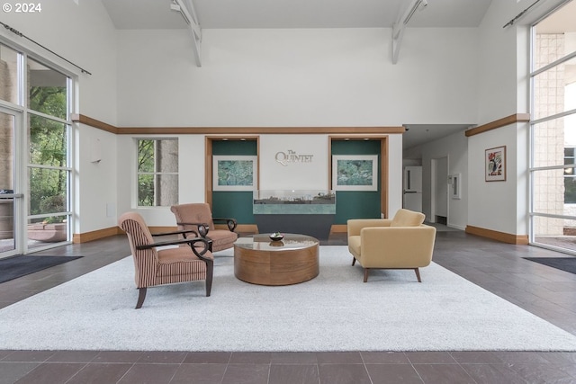 interior space featuring a towering ceiling and dark tile patterned floors