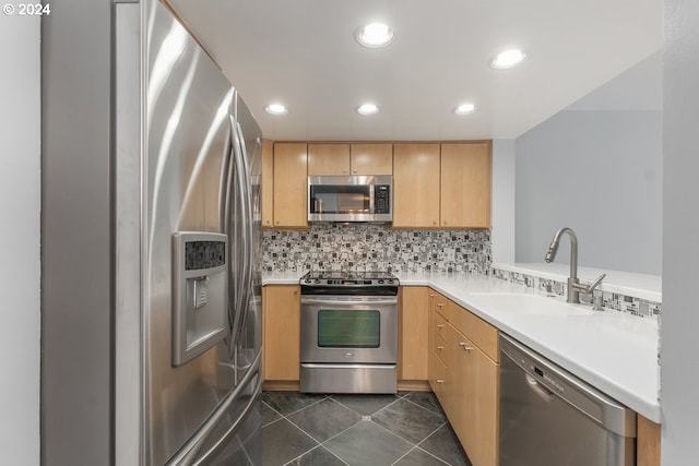 kitchen with light brown cabinets, decorative backsplash, stainless steel appliances, and sink