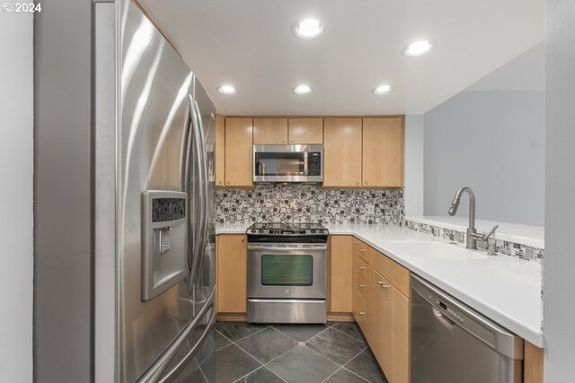 6605 W Burnside Rd Unit 144, Portland, OR 97210 - kitchen featuring appliances with stainless steel finishes, a sink, light brown cabinetry, light countertops, and tasteful backsplash