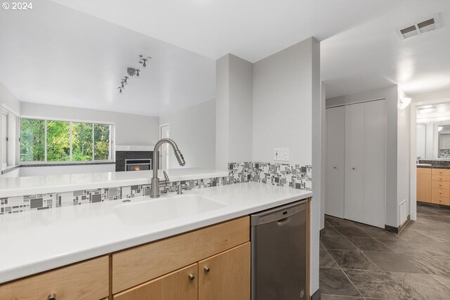 6605 W Burnside Rd Unit 144, Portland, OR 97210 - kitchen featuring dishwasher, a sink, decorative backsplash, light countertops, and a fireplace