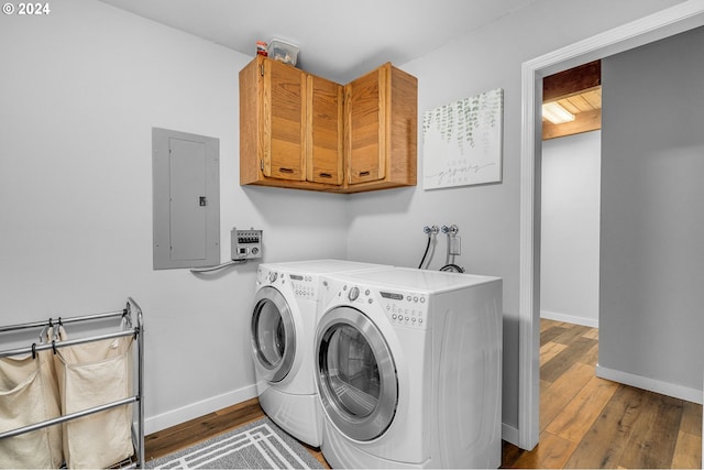 laundry room with independent washer and dryer, wood-type flooring, cabinets, and electric panel