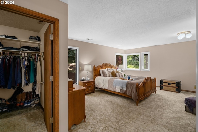 bedroom with a textured ceiling, carpet floors, and a closet