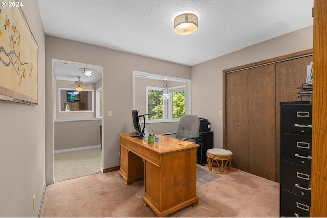 carpeted office with ceiling fan and a textured ceiling