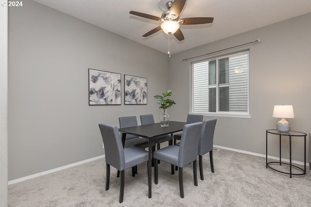 dining area with ceiling fan and light carpet