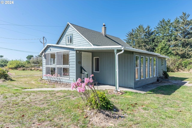 rear view of house featuring a yard