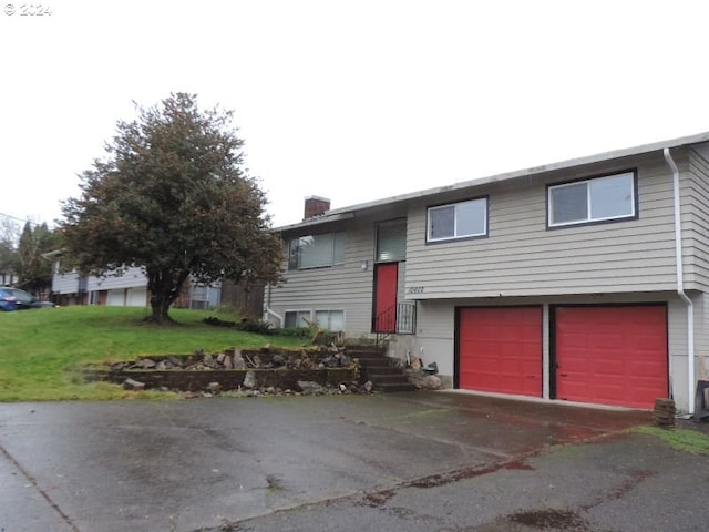 bi-level home with a front yard and a garage