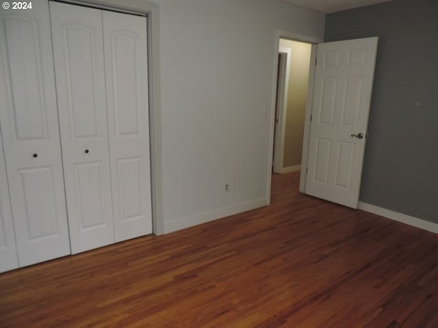 unfurnished bedroom featuring dark hardwood / wood-style floors and a closet