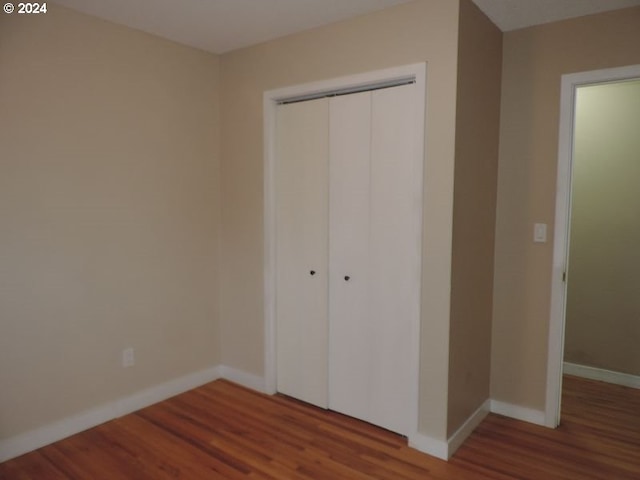 unfurnished bedroom with a closet and hardwood / wood-style flooring