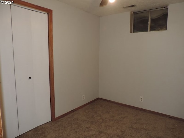 unfurnished bedroom featuring carpet, ceiling fan, and a closet