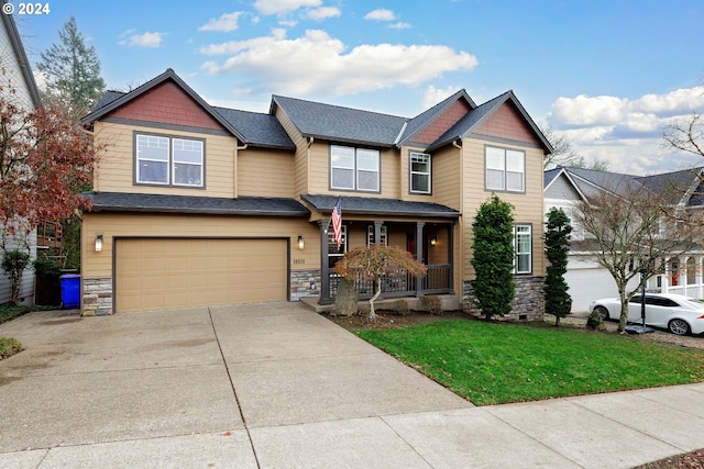 craftsman-style house featuring a front lawn, a porch, and a garage