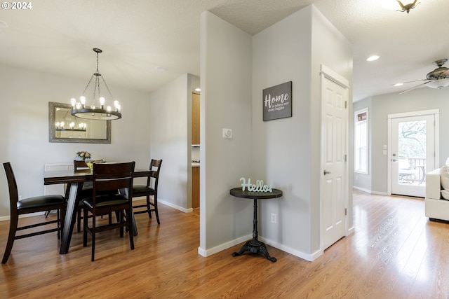 dining space featuring ceiling fan with notable chandelier and light hardwood / wood-style flooring