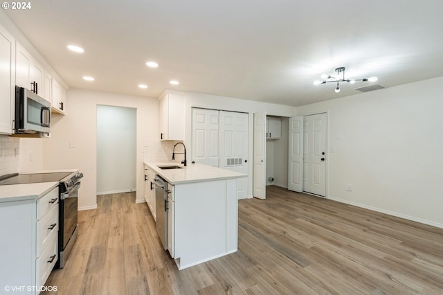 kitchen featuring decorative backsplash, light hardwood / wood-style floors, white cabinetry, and stainless steel appliances