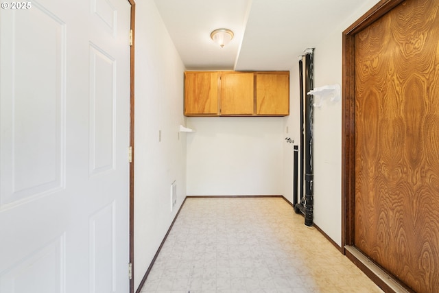 laundry room featuring baseboards and light floors
