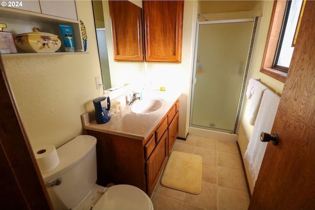 bathroom with tile patterned flooring, vanity, toilet, and walk in shower